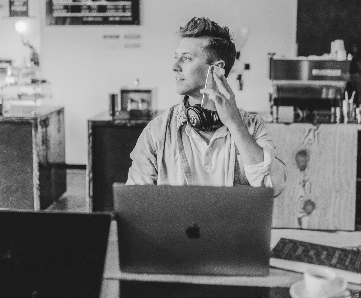 Eine Person sitzt an einem Tisch mit einem Laptop darauf in einem Café